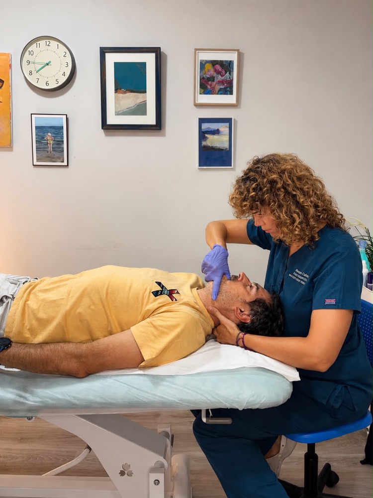 Terapia manual sobre la musculatura masticatoria durante una sesión en la clínica